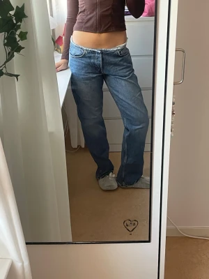 Coola Low waist straight jeans weekday - Super snygga lågmidjade jeans med raka ben från weekday. De är ”avhuggna” där knappen och gylfen brukar sitta vilket gör en snygg design. De är slitna nertill vilket man ser på den tredje bilden jag är 171 för längd referens.