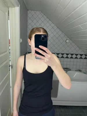 Svart linnetopp från VILA - En stilren svart linnetopp från VILA med smala justerbara axelband. Toppen har en enkel och klassisk design som passar perfekt till jeans eller kjol. Materialet är mjukt och följsamt, vilket gör den riktigt skön att bära.