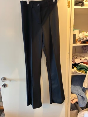Svarta kostymbyxor från Bubbleroom - Snygga svarta kostymbyxor från Bubbleroom i storlek S. Byxorna sitter åt över höften och är lätt utsvängda nedtill  Materialet är mjukt och har en elegant känsla, perfekt för en stilren look. Använt ett fåtal gånger då de är aning för korta för mig som är 167 cm.