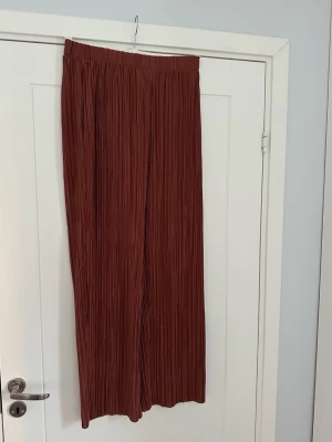 Plisserade  byxor från Lindex  - Säljer ett par plisserade  byxor Lindex. Byxorna har elastisk midja och är tillverkade i ett lätt syntetmaterial som ger ett flowigt och luftigt intryck. Perfekta för dig som gillar bekväma och trendiga plagg. Aldrig använda dock tvättade en gång :)