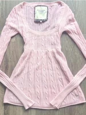 ✨ 00s Vintage Abercrombie & Fitch Pastel Pink Cable Knit Babydoll Top ✨ -  The ultimate Y2K coquette holy grail piece! Super rare vintage Abercrombie & Fitch long-sleeve knit top featuring  a gorgeous empire waist babydoll cut, classic scoop neckline, and intricate all-over cable knit texture. Beautiful soft baby pink colorway with iconic fitted sleeves and the signature mini embroidered moose logo near the hem. Perfect fairygrunge, mcbling, or balletcore aesthetic. Details: •          What you’re receiving: printed photo of the top for ur moodboard