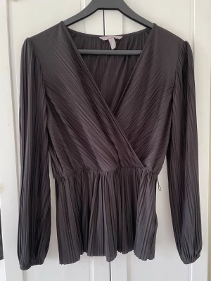  Svart blus -  Svart blus i storlek S ifrån H&M .  Blusen är omlott med en V-ringning. 
