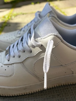 Vita Nike Air Force 1 sneakers - Nike Air Force 1 – Storlek 41  Säljer ett par klassiska vita Nike Air Force 1 i storlek 41. Stilrena och enkla sneakers som passar till nästan allt. 👟  Skorna är använda några gånger och är i jättebra skick. Crease-skydd följer med.  Storlek: 41 Färg: Vit Kartong: Följer inte med då den är borttappad.