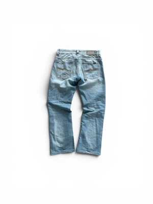 Nudie Bootcut Ola - Säljer ett par ljusblå bootcut jeans från Nudie. Modellen heter Bootcut Ola och är en mycket eftertraktad modell på grund av att den inte längre tillverkas. Storleken är w31 l32 men dom är små i storlek. Midjan är 40cm kant till kant och längden på benets yttre sida är 90cm!