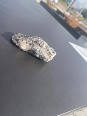 Unik mineralsten i grå och vit - Säljer en cool mineralsten med grå och vita nyanser samt inslag av ljusrosa. Stenen har en ojämn, naturlig form och passar perfekt för dig som gillar kristaller, dekoration eller samlar på stenar.