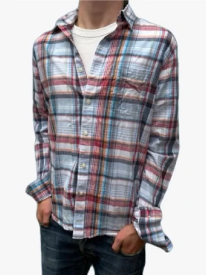 Rutig skjorta i bomull - Snygg rutig skjorta i bomull med blå, röda och vita toner. Skjortan har klassisk krage, knäppning framtill och en bröstficka. Perfekt för en avslappnad och trendig look.