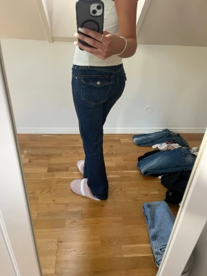 Mörkblå bootcut jeans - Säljer ett par mörkblå bootcut jeans.  Materialet är denim i bomull.