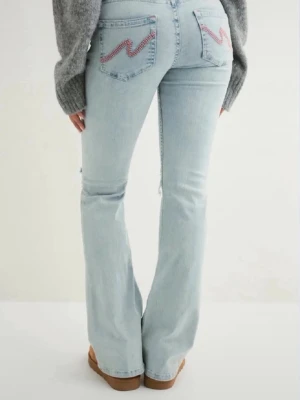 Ljusblå bootcut jeans med brodyr - Säljer ett par ljusblå bootcut jeans med utsvängda ben och snygg rosa brodyr på bakfickorna. Jeansen har hög midja och klassisk femficksdesign. Perfekta för en trendig och avslappnad stil. Skicket är som nytt. Priset är diskuterbart