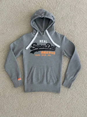 Superdry Hoodie Grå - Superdry Hoodie grå - Storlek: S - Pris: 599kr - Väldigt fint skick och fräsch. - Först till Kvarn!