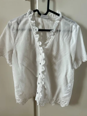 Vit blus/kofta/tröja med spetsdetaljer - Vit tunn blus med spetsdetaljer och ihåliga kanter.(Använts 2x) original pris (400)