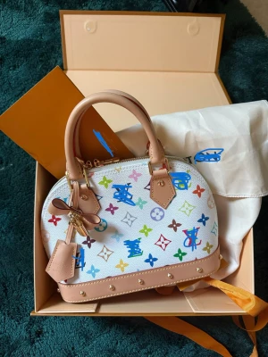Vacker färgglad väska - Vacker färgglad väska, tillverkad av syntetmaterial, chic, elegant och avslappnad, levereras med ask och dustbag, har även en axelrem, en härlig sommarväska.