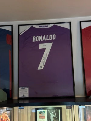 En 100% äkta Cristiano Ronaldo signerad Real Madrid matchtröja+Äktenhetsbevis. - Säljer en 100% äkta Cristiano Ronaldo autograf (signerad Real Madrid tröja) med genuint äktenhetsbevis från Beckett. (Beckett är 1 av 3 seriösaste äktenhetsbevis företagen i världen när det kommer till autentisering av autografer) äktenhetsbeviset är ett klistermärke med ett unikt serie nummer och QR kod för ju denna autograf. Signerade Cristiano Ronaldo tröjor är värderade till 15-20 000kr i dagsläget men värdet går upp varje dag! Säljs för endast 7999kr vid en snabb affär.. Mvh Elliot.