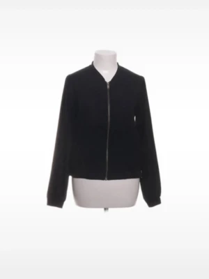 Svart klassisk bomberjacka - En stilren svart bomberjacka med dragkedja framtill och ribbade muddar vid ärmar och midja. Jackan har en minimalistisk design och passar perfekt till streetwear eller en avslappnad look. Tillverkad i ett mjukt tyg som ger en bekväm känsla.