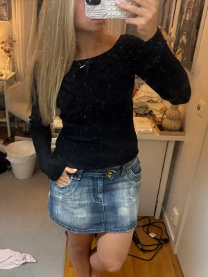 Svart tröja - En svart långärmad tröja med rund halsringning och slim passform. Tröjan är enkel och stilren, perfekt att matcha med olika underdelar för en clean look. 
