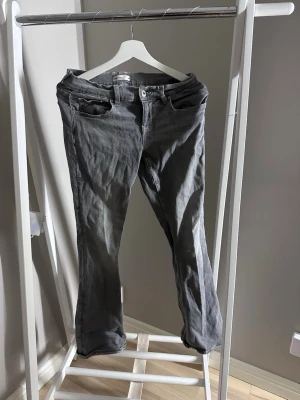 Low waisted Gråa flared jeans - Gråa flared jeans från Gina tricot med mönster på fickorna, i storlek 38