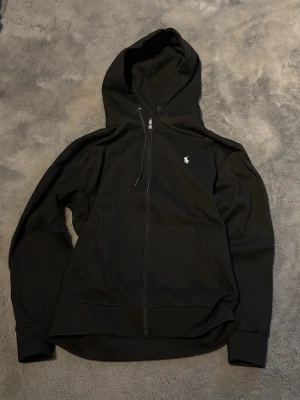 Ralph lauren zip up - Denna zip up hoodie är i toppskick och har bara använts få tal gånger (2-4ggr). Den har inga defekter och är perfekt till hösten och vintern. Storlek M 