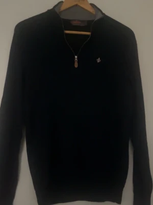  Morris half-zip tröja - Stilren Mörkblå tröja från Morris med halvzip och en liten broderad logga på bröstet. Tröjan har långa ärmar och ribbade muddar. Perfekt för lager-på-lager och snygg till jeans eller chinos. Också några så defekter men inte så synliga. 