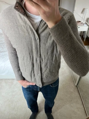 Beige cardigan jacka från Massimo Dutti - Tvär fet cardigan med stickade ärmar i ett bra skick! Cardiganen är tillverkad i cashmere/ull och är i storleken M men sitter som S 😁                   ——————————————————————————                                                            📐| Storlek: M men sitter som S                                                            👖| Märke: Massimo Dutti                                     🔎| Skick: Bra skick!                                               ✍🏻| Skriv om du har några frågor