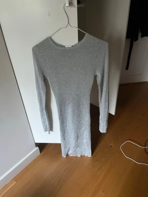 Silverglittrig långärmad klänning - Säljer en helt ny klänning från C.W. Köpte den här till nyår men fick aldrig användning av den. Nu passar den tyvärr inte så måste sälja. Den är i storlek S