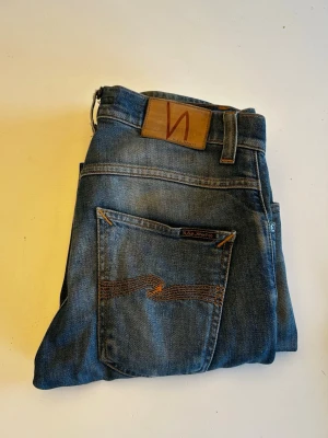 Blå jeans från Nudie Jeans - Säljer ett par klassiska blå jeans från Nudie Jeans i modellen Grim Tim. Strl: 28/32. Skriv innan köp. Pris:399kr