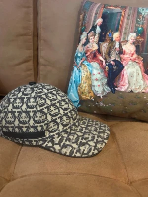Feregamo keps - Snygg keps i beige med svart grafiskt mönster över hela ytan. Klassisk böjd skärm och justerbar rem bak. Perfekt accessoar för att lyfta din streetwear-look. Tillverkad i ett slitstarkt tygmaterial. Äkta 