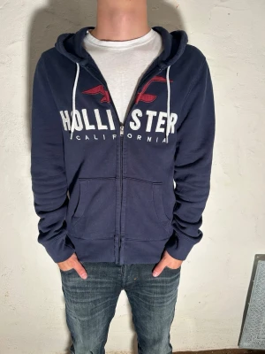 Hollister hoodie~vintage - Snygg marinblå hoodie från hollister i storlek M. Modell är 185cm. Priset går att diskuteras vid snabbaffär. Skriv vid minsta fundering.