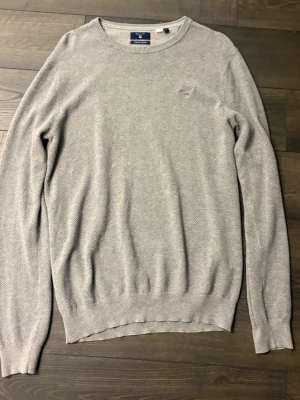 Ljusgrå stickad sweatshirt Gant - Ljusgrå stickad sweatshirt från Gant med rund halsringning. Storlek:L 