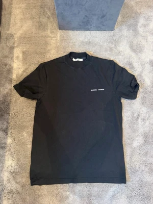 Svart t-shirt från Samsøe Samsoe  - En svart t-shirt från Samsøe Samsoe. Tröjan är aldrig använd och är i 10/10 skick. Tröjan är oversize och skulle passa allt från S-L beroende på önskad passform