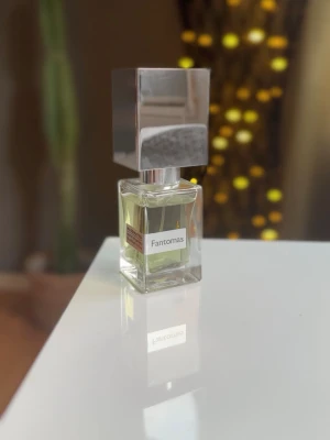 Nasomatto Fantomas parfym - Unik parfym från Nasomatto, Fantomas, i en stilren glasflaska med silverfärgat fyrkantigt lock. Flaskan rymmer 30 ml. Köpt på NK i Stockholm för något år sen och har original box med men tyvärr inget kvitto, parfym är förvarad väll. Jag skulle tippa det är isch 25 ml kvar då den är väldigt snålt använd.