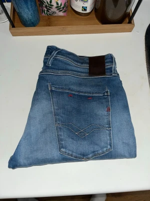 Replay hyperflex jeans  - Snygga blå jeans i slim fit-modell med klassiska fem fickor och coola slitningar framtill. Jeansen har kontrastsömmar och en liten röd detalj på bakfickan. Perfekta för en avslappnad och trendig look. Midja 42cm längd 93cm. . JAG SKICKAR EJ FLER BILDER NÄR JAG BÄR JEANSEN! för bättre inblick i passformen rekommenderar jag att googla på modellnamnet. För storleksguide kolla måtten noggrant då jeansen alltid kan vara uppsydda heller krympta och jag ej tar emot returer :) R40
