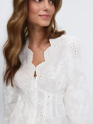 Vit broderad blus med spetskant från Gina Tricot  - Oanvänd, Romantisk vit blus med broderade blommor och hålbroderier. Blusen har långärmad design, figurnära passform och vacker vågig spetskant vid halsringning och nederkant. Knäppning framtill och lätt puffade ärmar ger en trendig vintagekänsla. Perfekt till jeans eller kjol.