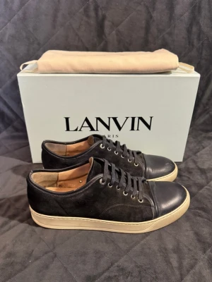 Lanvin - Vi säljer ett par eftertraktade, mörkblå lanvins captoe i storlek uk8 vilket motsvarar storleken 42. Skorna passar även storlek 43! Skorna är självklart äkta! Skorna är i mycket bra skick 8/10, de har endast en tydligare defekt på insidan, detta är en vanlig defekt på den specifika lanvin modellen! Skorna har inga andra tydliga defekter och behöver i princip endast rengöras lite, så är de som nya! Därav har vi satt priset på 1699kr! Kom gärna med frågor, box o dustbag ingår ej
