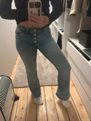 Ljusblå bootcut jeans med knappar