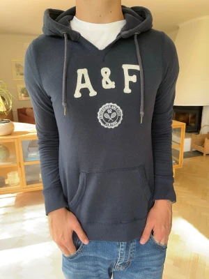 Abercrombie & Fitch vintage hoodie mörkblå herr  - Snygg marinblå hoodie från Abercrombie & Fitch med klassisk broderad A&F-logga och emblem framtill. Stilren design som passar perfekt till vardags och är enkel att matcha. Fint skick med normalt bruksslitage.  #Abercrombie #AbercrombieAndFitch #AF #Hoodie #Sweatshirt #Navy #Vintage #Streetwear #Preppy