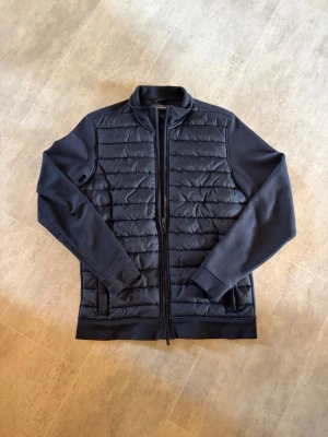 Mörkblå cardigan från dressman  - Snygg mörkblå cardigan från dressman med framsida och släta ärmar. Tröjan har hög kvalité och ända felet är färgen på bild tre. Det går säkert att lösa om man är lite kreativ, men färgen syns inte om inre någon är jätte nära dig😊