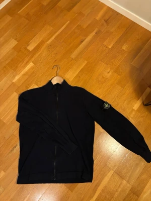 Stone Island Tröja - Tjena, säljer denna snygga och versatila Stone Island zip up tröja. Jag säljer den nu då jag inte har någon användning av den längre. Storleken är M, har inga defekter eller fläckar. Nypris ligger på 4400 men säljer den för 1000, och priset är inte fast så lägg bud! Kvittot och påsen finns kvar. Kontakta för mer information och bilder👍
