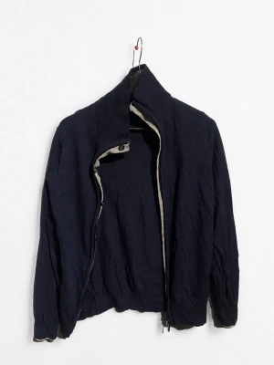 Libero Milano Cashmere Zip Cardigan – Navy – Strl 46 - Exklusiv mörkblå zip cardigan från Libero Milano i cashmere, storlek 46. Stilren italiensk design med hög ribbad krage, kontrasterande ljus insida och dubbel dragkedja. Väldigt mjuk och lyxig kvalitet som fungerar perfekt både till vardags och mer dressade outfits.  Köpt i butik i Milano. Begagnat skick – se bilder för skick. Säljs då den inte kommer till användning.  📦 Skickas snabbt  💬 Skriv gärna vid frågor 🛍️ Se gärna mina andra annonser –