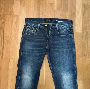 Replay jeans - Limiterade replay jeans🔥                              storlek 30x32. Modellen är anbass slim fit.🔥  Skickas oftast samma dag📦                              Det är snygga mörkblå jeans från Replay med coola slitningar och tvättade detaljer. Klassisk femficksmodell med neon-grön knapp och Replay-logga på bakfickan. Jeansen har en modern passform och är tillverkade i denim med skön stretch.👖