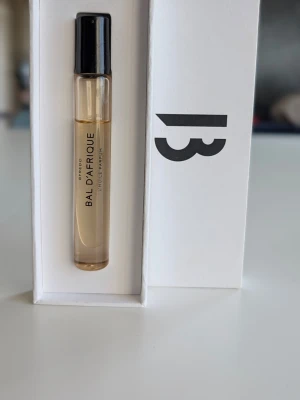 Byredo Bal d'Afrique Eau de Parfum - Byredo Bal d'Afrique Eau de Parfum i en smidig provflaska. Flaskan är genomskinlig med svart lock och parfymen har en ljusgul ton. Kommer i en stilren vit förpackning med Byredo-logga. Perfekt att ha med i väskan för en fräsch doft när som helst. Se bild för skick.