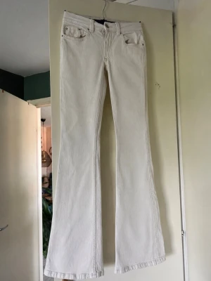 Vita bootcut jeans med broderad ficka - Säljer ett par vita bootcut jeans med snygg broderad detalj på bakfickan. Jeansen har klassisk femficksmodell och är tillverkade i ett mjukt bomullsmaterial med lite stretch. Perfekta för dig som gillar en avslappnad men trendig look.