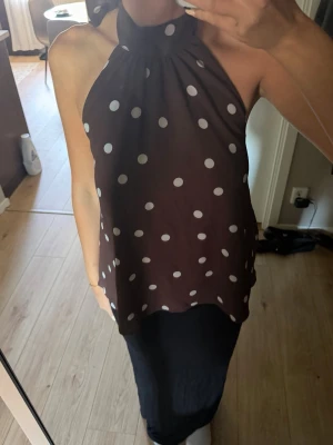 Brun prickig halterneck topp - brun halterneck topp med vita prickar och knyt i nacken. Använd 3 ggr 