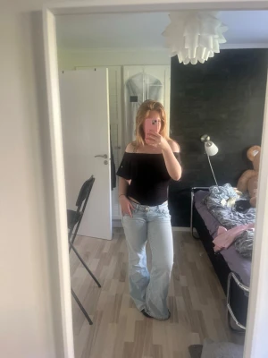 Topp - Snygg svart offshoulder topp med bred volang runt axlarna. Toppen är tight och har en croppad passform som passar perfekt till höga jeans eller kjol. Enkel men trendig design som ger en cool vibe. DEN HAR INGEN FLÄCK, bara spegeln som är smutsig!!!!!