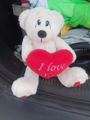 Vit nallebjörn med rött hjärta - Söt vit nallebjörn i mjuk plysch som håller ett rött hjärta med texten 'I love you'. Perfekt som present till någon du tycker om. Nallen har broderade ögon och nos samt röda detaljer på tassarna.