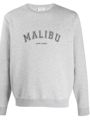 Grå Saint Laurent tröja - Säljer en grå sweatshirt från Saint Laurent med texten MALIBU tryckt framtill. Tröjan har rund halsringning, långa ärmar och ribbade muddar vid ärmslut och nederkant. Perfekt för en avslappnad och trendig look. Priset kan diskuteras vid snabb affär