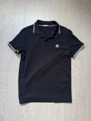 Svart moncler piké - Svart moncler piké, storlek M. Pris går att diskutera och det finns inga summar frågor!