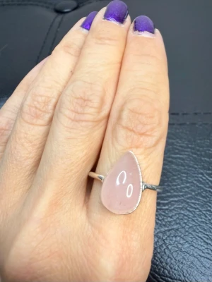 Handgjord 925 Silverring med Rosenkvarts – Ädelsten för Kärlek & Harmoni - Ny och oanvänd handgjord ring i stämplat 925 silver med droppformad rosenkvarts. Skapad av en kvinnlig silversmed som arbetar mycket småskaligt och väljer varje ädelsten med omsorg. Rosenkvarts förknippas traditionellt med kärlek, harmoni, omtanke och inre lugn. Mått ca: höjd 1,6 cm, bredd 1,1 cm, djup 0,9 cm, innerdiameter 2 cm. Jag prutar inte, men erbjuder gärna bundelrabatt. Kika gärna på mina andra annonser också!  