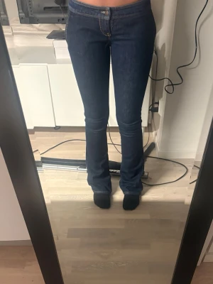 Mörkblå bootcut jeans - Säljer ett par mörkblå bootcut Roberto cavalli jeans, jeansen är låg midja men har tyvärr en sönder dragkedja men ingenting som syns när man har på sig jeansen