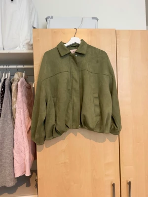 Olivgrön bomberjacka från Nelly - Säljer en olivgrön bomberjacka från Nelly i mjukt material med krage och dragkedja framtill. Jackan har två fickor och en loose passform som ger en avslappnad look. Perfekt för dig som vill ha en trendig jacka till hösten. Använd 2ggr. Nypris 699 mitt pris 300