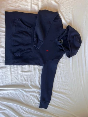 Mörkblå hoodie med röd logga - Snygg mörkblå hoodie med huva. Perfekt för en avslappnad och stilren look. Pris går att diskutera