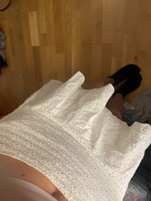 Vit kortkjol med broderade detaljer - Söt vit kortkjol med broderade blommönster och volangkant. Kjolen har en luftig och lätt passform, perfekt för varma dagar. Materialet känns mjukt och andas bra. Enkel att matcha med olika toppar för en fräsch look.